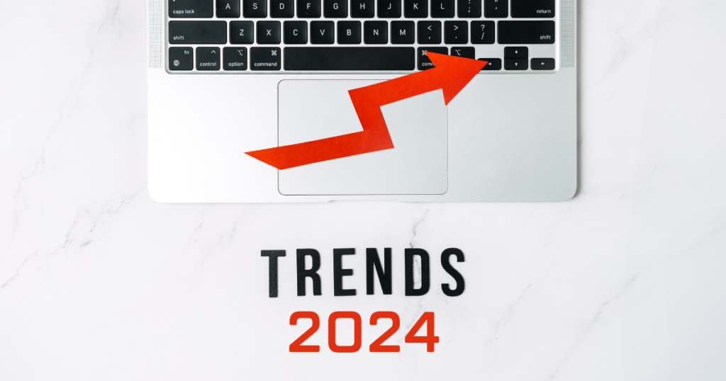 A laptop keyboard with a red arrow pointing to the right, signaling the new year is coming with Trends 2024 written below it on a white surface.