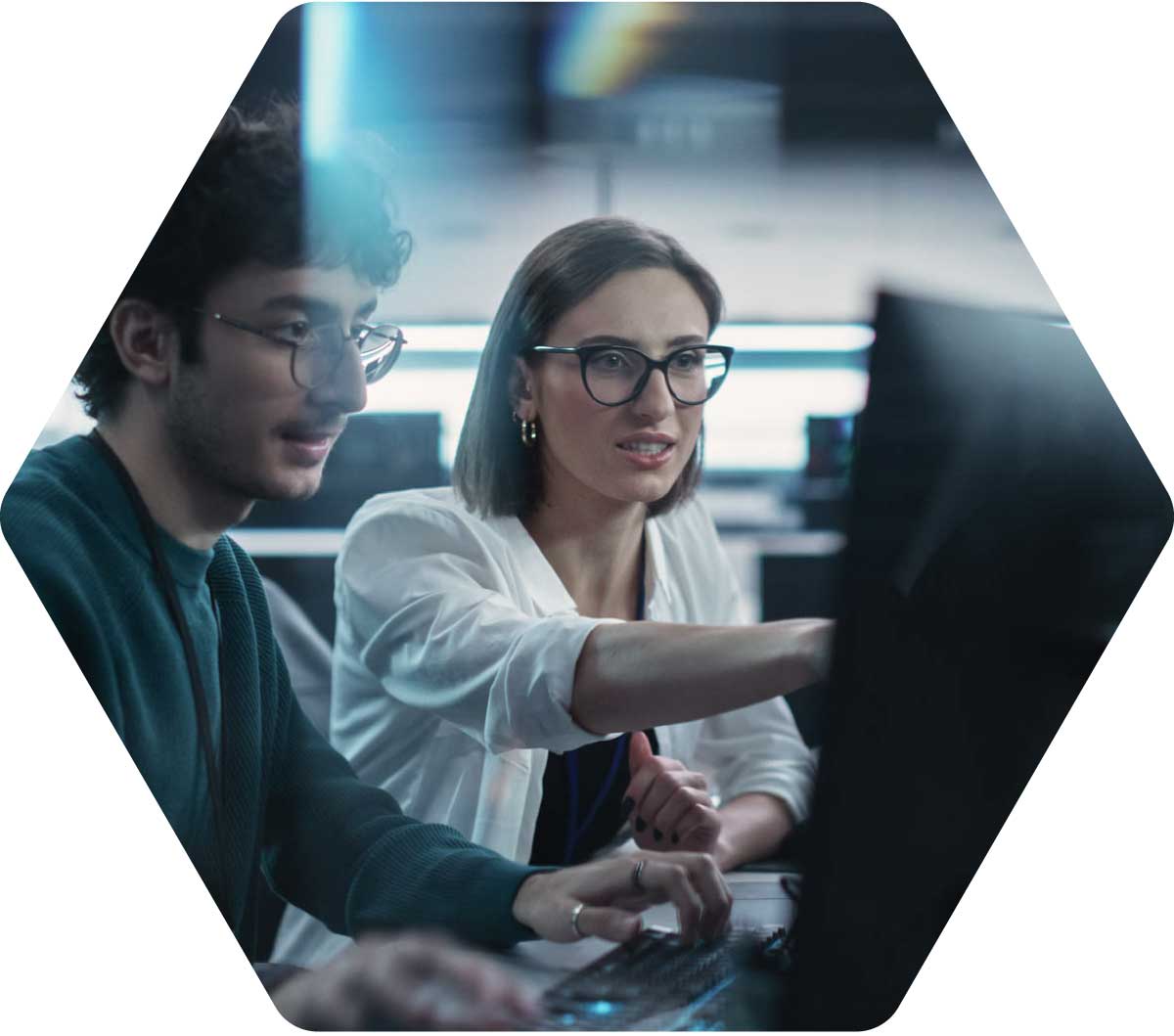 Two-Young-Colleagues-Working-on-Computers-and-Talking-at-a-Workplace-2